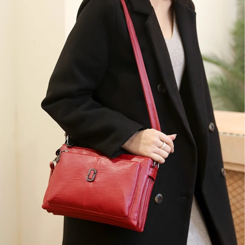Fitlybuy Fosh small red leather shoulder bag with premium finish, worn by a woman in a black coat.