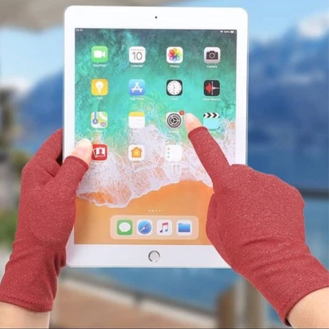 Hands wearing red Fitlybuy therapeutic heat gloves, touching the screen of a white tablet.