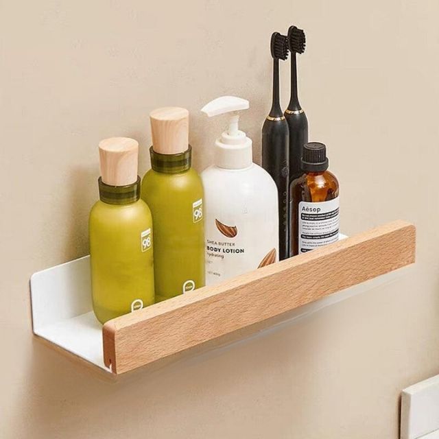 Fitlybuy solid wood and white metal wall-mounted bathroom shelf holding skincare bottles and toothbrushes.