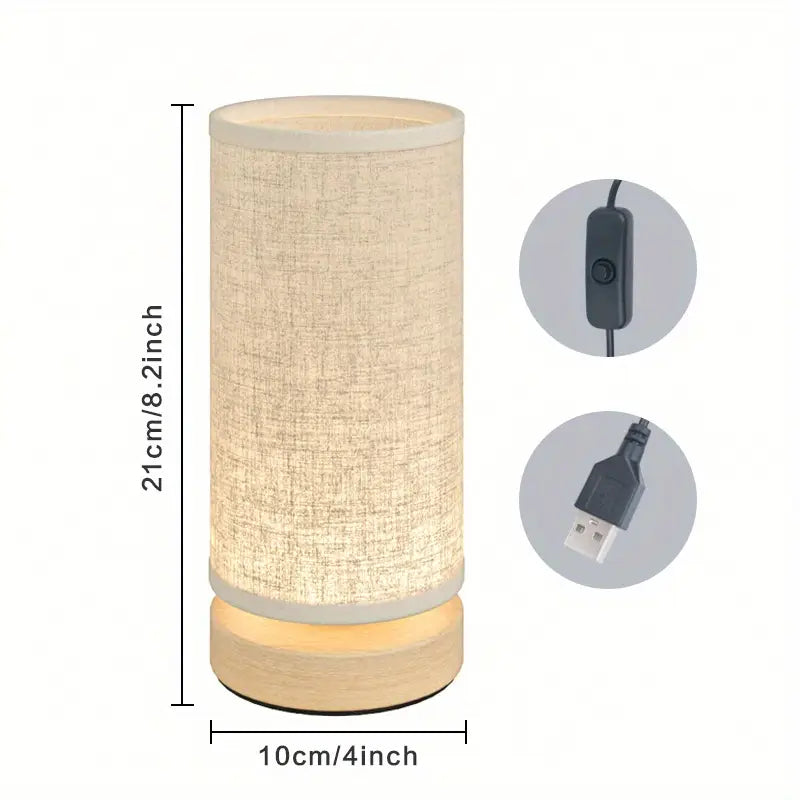 Minimalist wooden cylinder lamp with warm fabric shade, 8.2-inch height, USB-powered with an inline power switch.