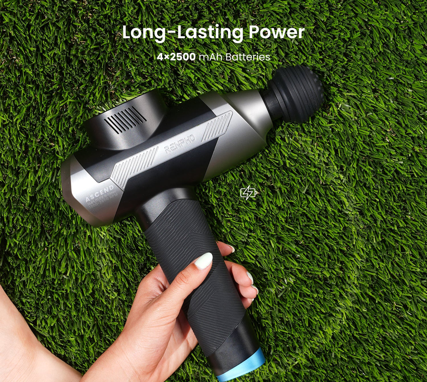 Black and silver Fitlybuy Ascend massage gun held over green grass, highlighting HyperPulse battery power.