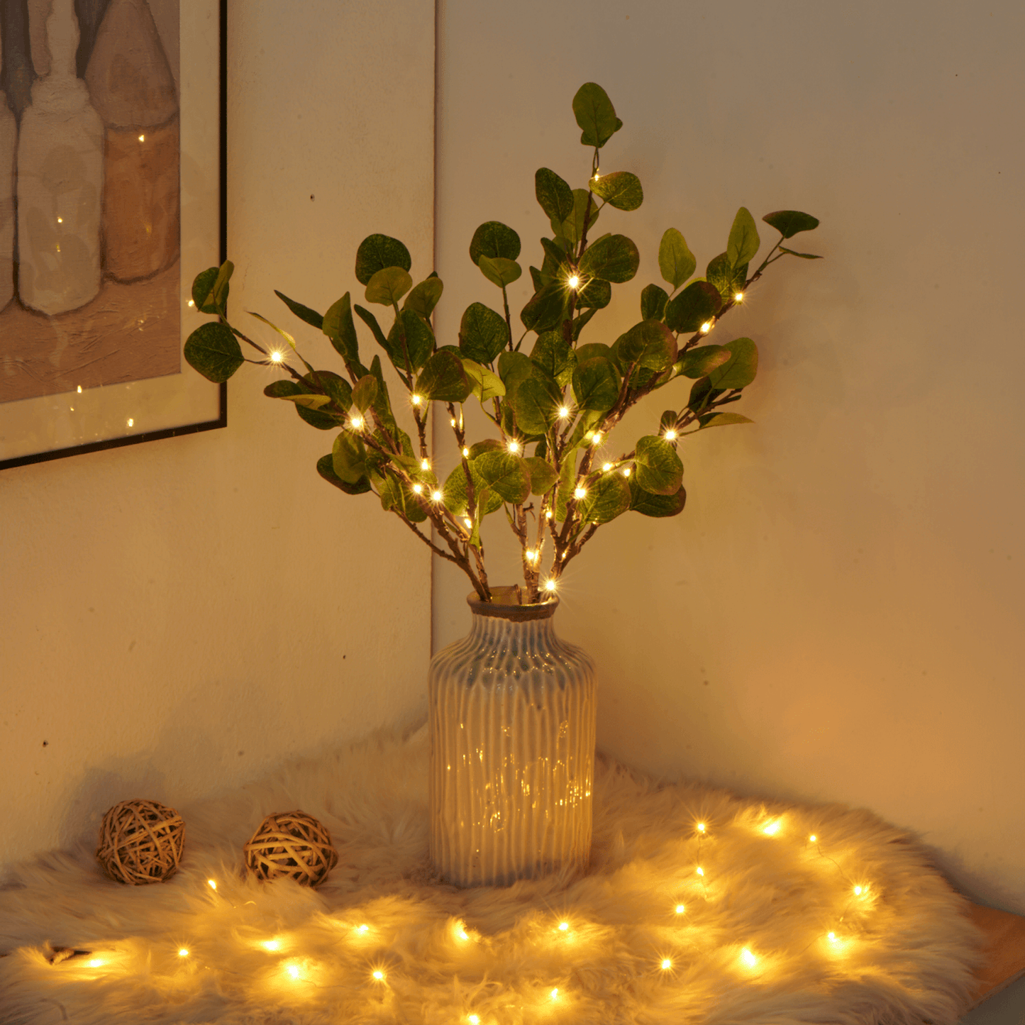 Fitlybuy LumiVista olive branch LED string light in a textured vase on a fuzzy rug with warm ambient lighting.