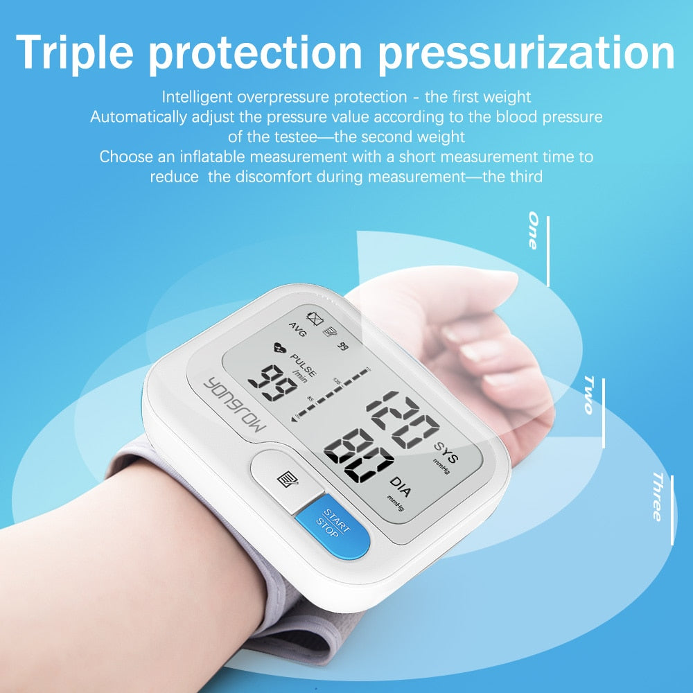 White Fitlybuy digital wrist blood pressure monitor with blue start button on a person's wrist against a blue background.