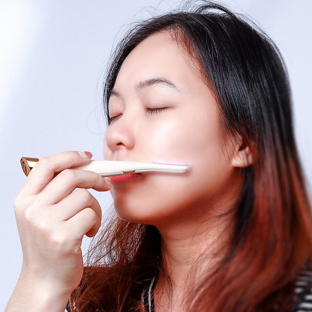 A woman uses a white and gold Fitlybuy SoftSkin painless facial hair remover on her cheek.