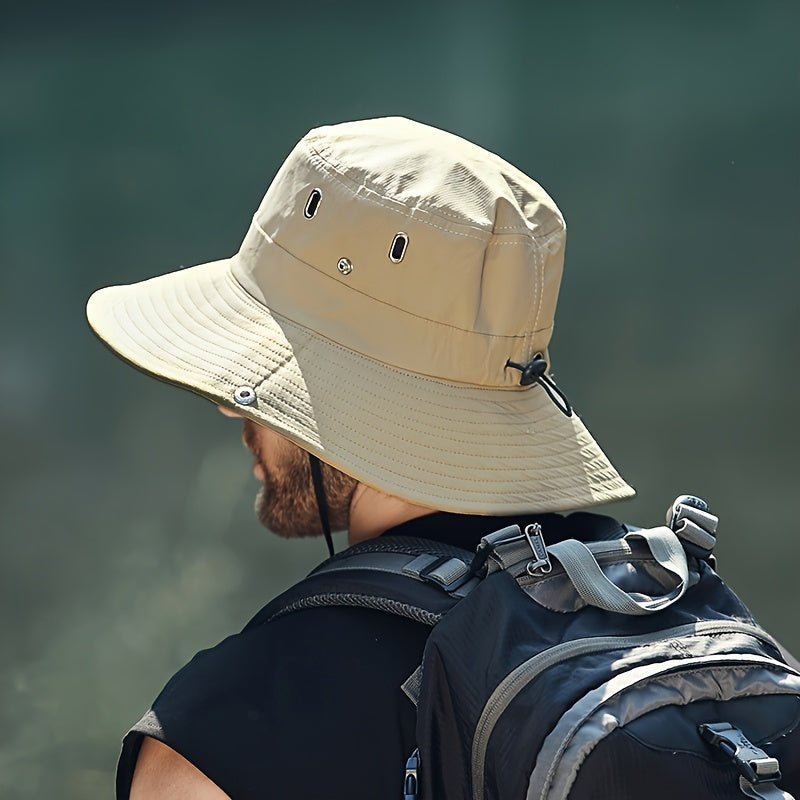 Man wearing a beige Fitlybuy SUNSAFE breathable UV sun hat with side vents and adjustable cord while hiking.