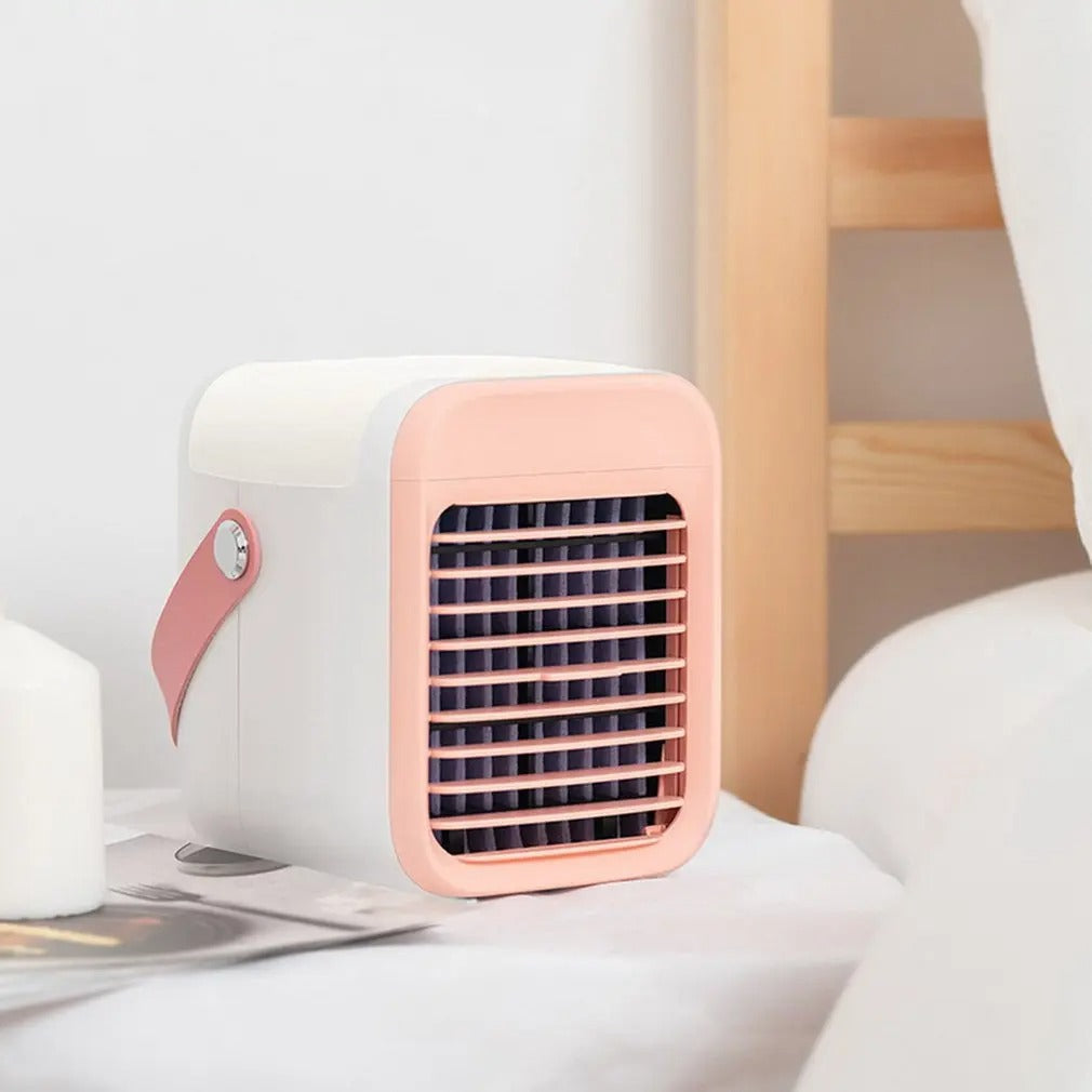 Fitlybuy portable 3-in-1 mini air conditioner in white and pink with a carry handle, sitting on a bedside table.