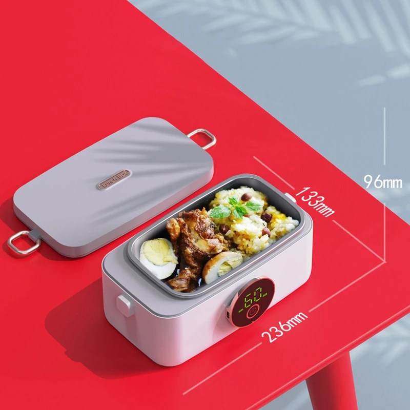 Fitlybuy HeatMate Pro: Grey portable heated lunchbox with digital temp display, containing food, on a red table.