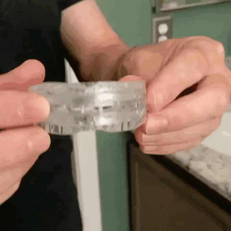 Hands holding a clear, transparent Fitlybuy anti-snoring mouth guard for sleep with ComfortFit customization design.