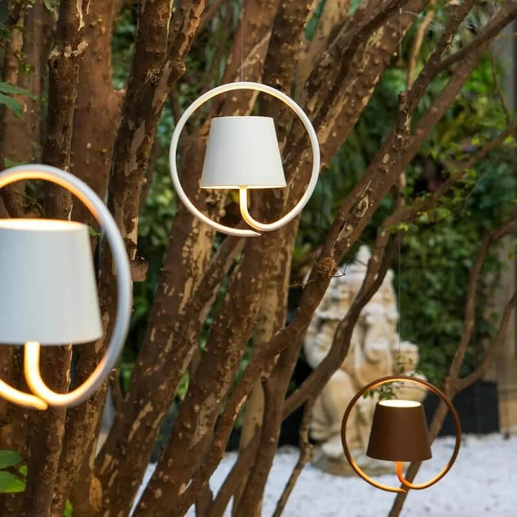 Fitlybuy LumiCord wireless hanging ring lamps with white or brown shades, glowing in a lush garden setting.