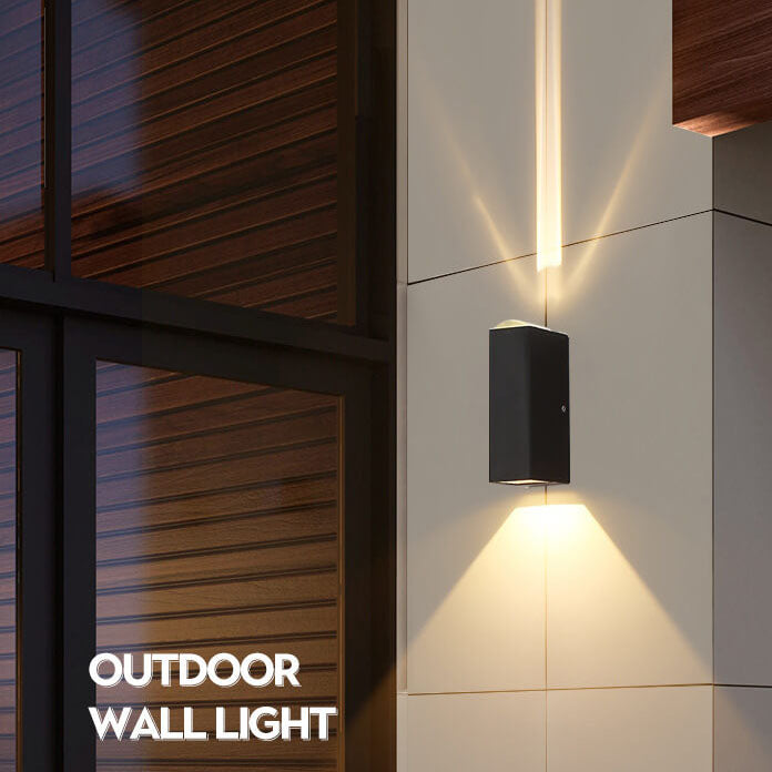 Black rectangular waterproof LED outdoor wall light fixture mounted on a modern exterior wall with warm up-down lighting.