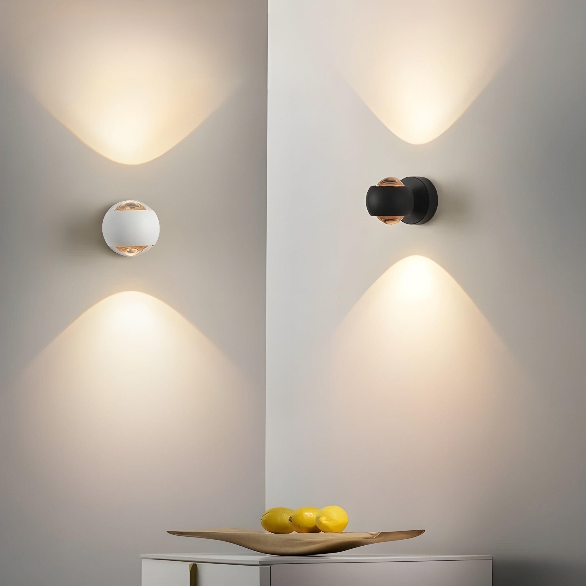 ModernEdge 360° rotating LED wall lights in black and white, emitting up-down warm light on a corner wall with fruit.