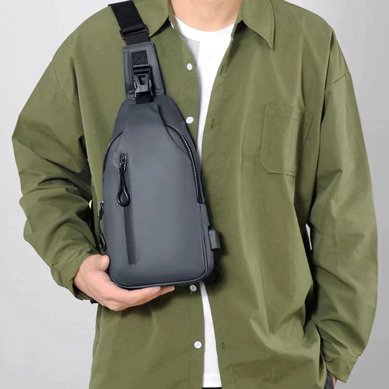 Person wearing a grey Fitlybuy waterproof anti-theft crossbody bag with a SecureLock buckle on the front.