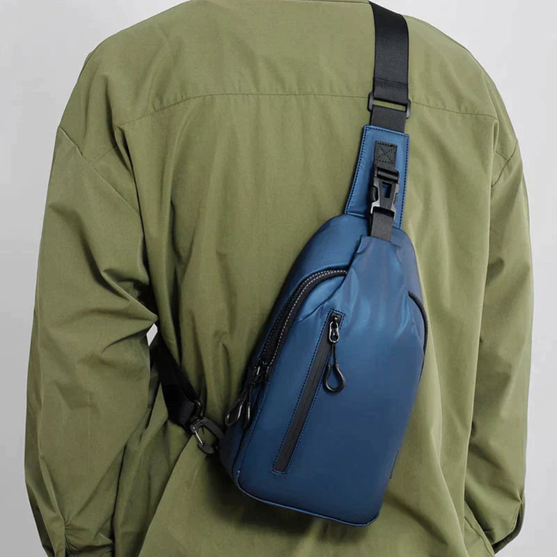 Blue Fitlybuy anti-theft crossbody bag worn over a green jacket, featuring secure zippers and adjustable strap.