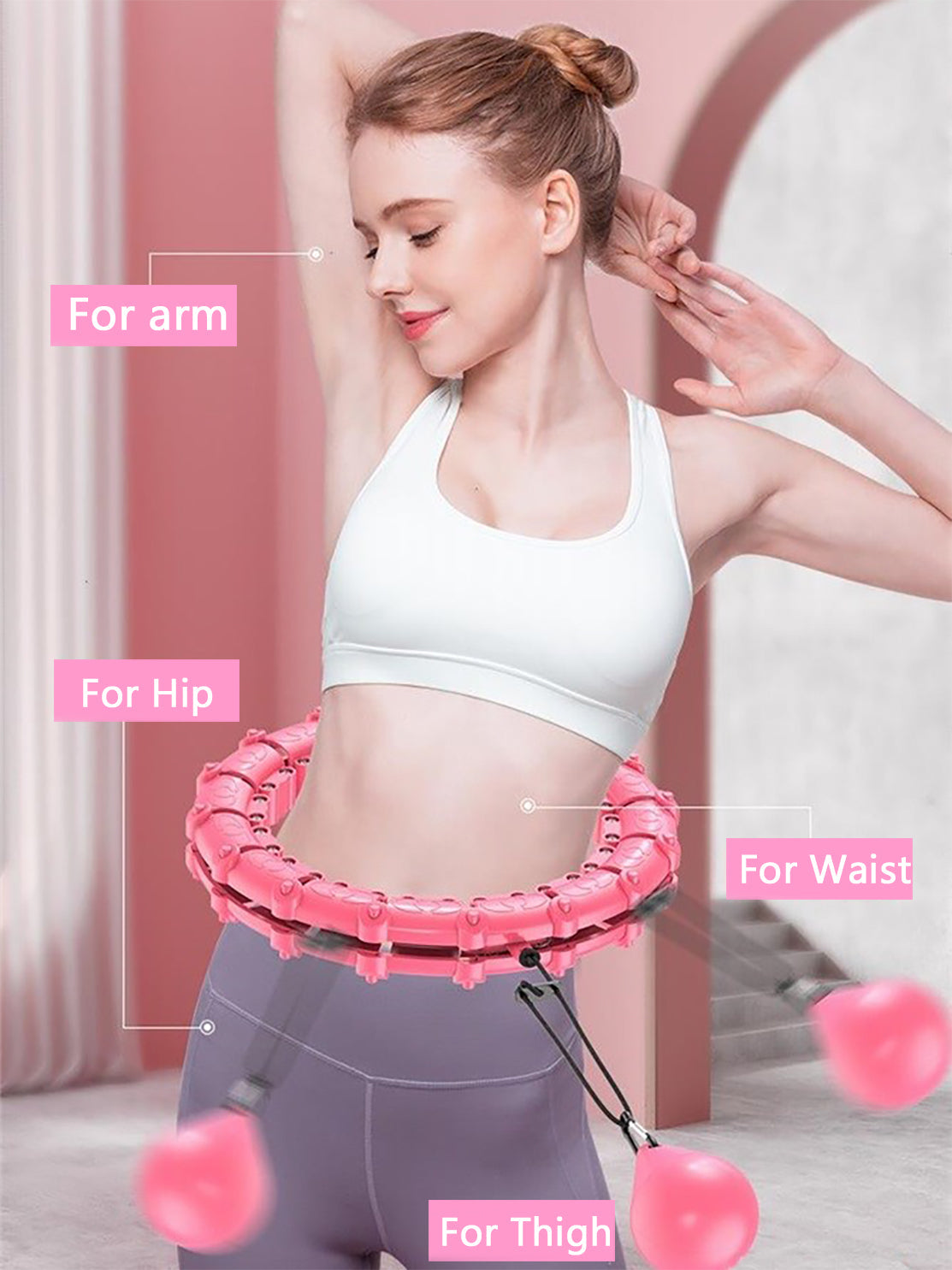 Woman wearing a pink, adjustable Fitlybuy smart hula hoop with weighted balls for arm, hip, waist, and thigh exercise.