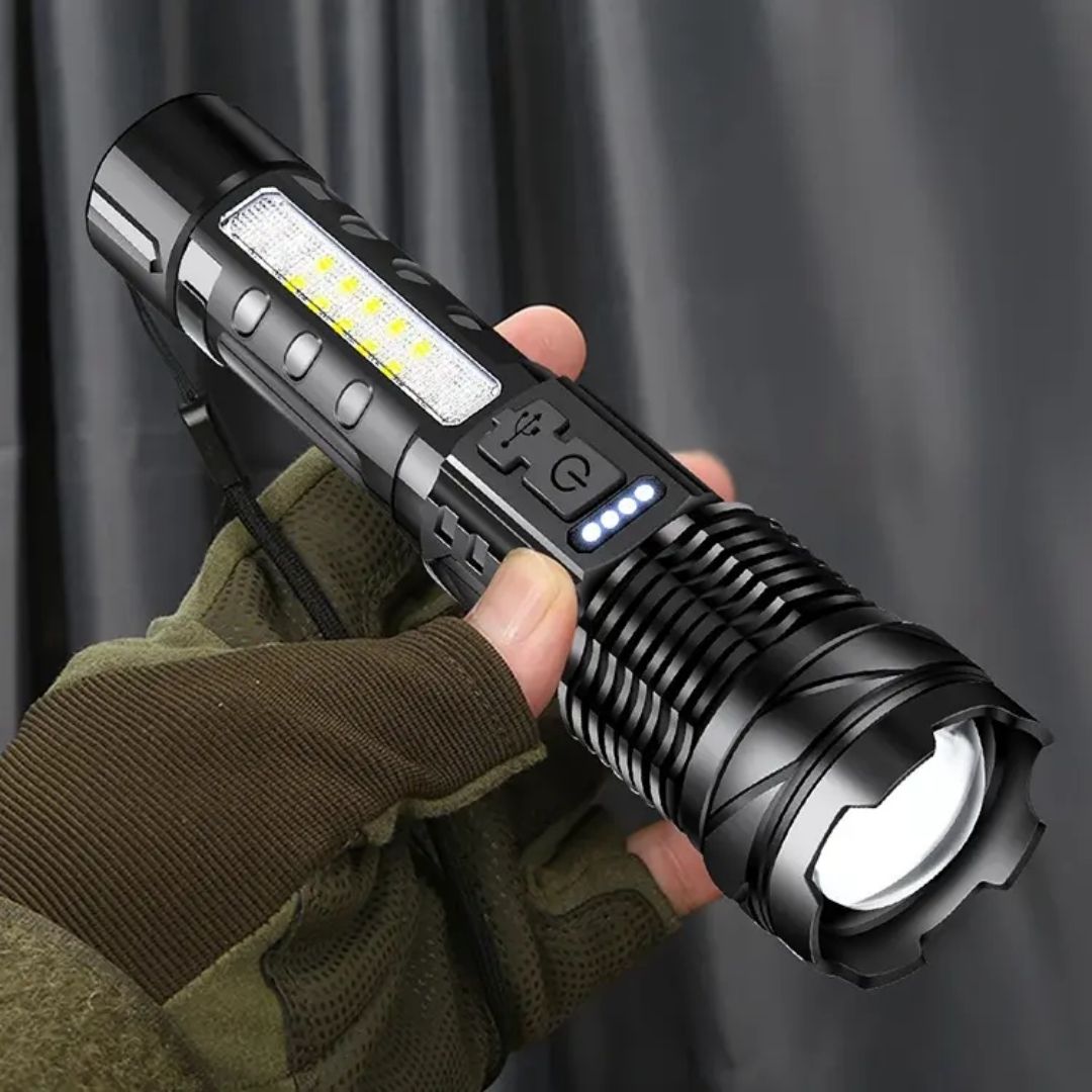 Black Fitlybuy zoomable LED flashlight with COB side light, USB port, power indicator, held by a hand in a glove.