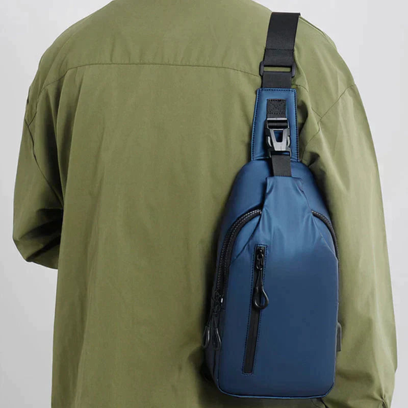 Blue Fitlybuy waterproof anti-theft crossbody bag with black strap and SecureLock worn over a green shirt.