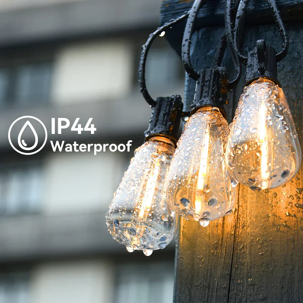 Fitlybuy IP44 weatherproof LED string lights with warm glowing bulbs hanging on a post in the rain.