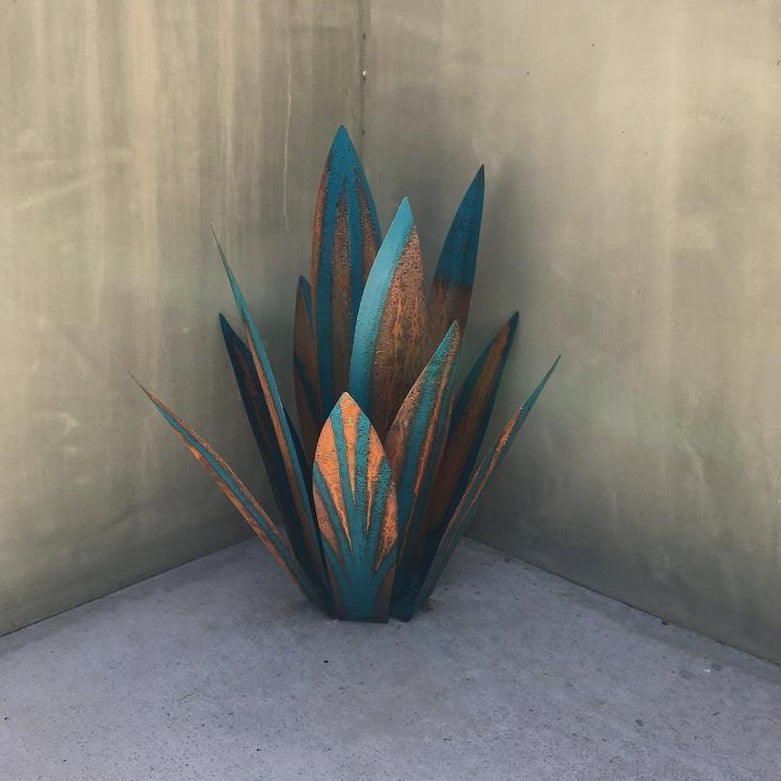 Fitlybuy Eternal Agave metal garden sculpture with teal and rusted copper finish, standing in a corner.