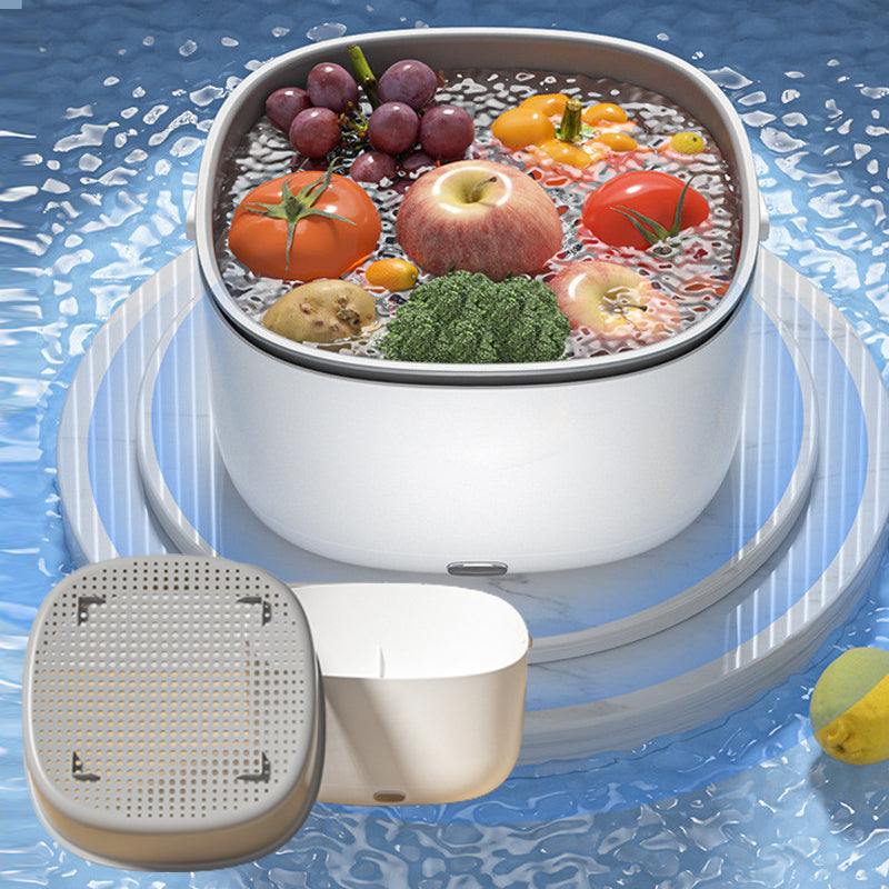 White Fitlybuy FreshWave ultrasonic cleaner soaking fruits and vegetables in water on a blue, rippling pedestal.