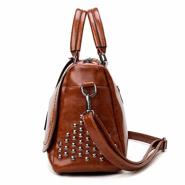 Side view of a brown leather Fitlybuy shoulder bag featuring silver stud embellishments and a detachable strap.