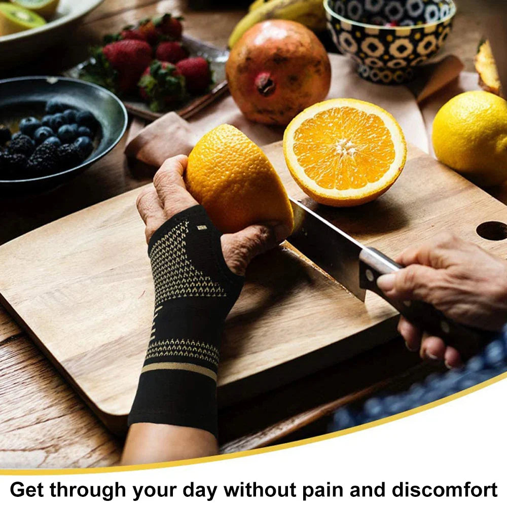 Fitlybuy Flex black and gold compression glove worn on a hand slicing an orange on a wooden cutting board with fruit.