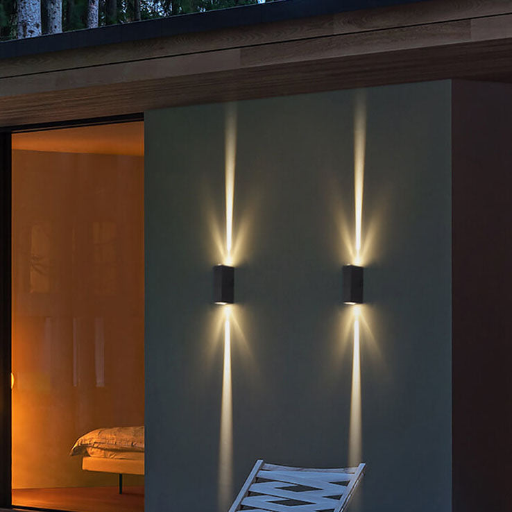Two rectangular, black waterproof LED wall lights illuminate a modern home exterior with up-and-down beams.