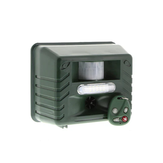 Green Fitlybuy ultrasonic woodpecker repeller with motion sensor, LED light, and handheld remote on white background.