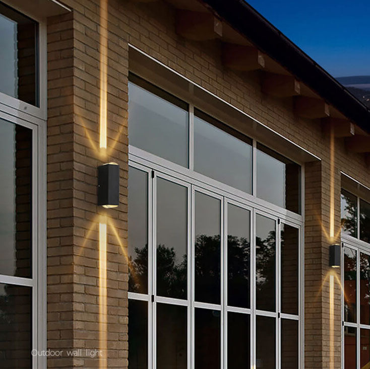 Modern black rectangular waterproof LED outdoor wall lights illuminate a brick house exterior with a warm up-down glow.