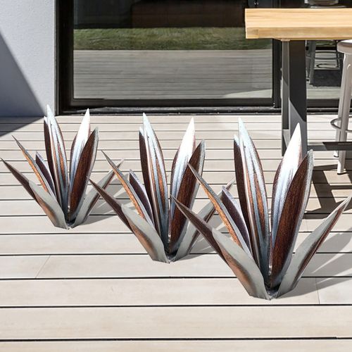 Three handcrafted, rust-proof metal agave sculptures with metallic brown and silver leaves on a patio deck.