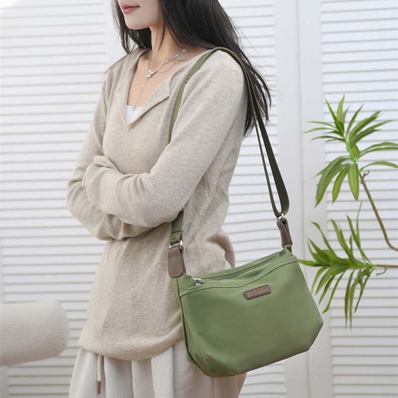 Woman wearing an olive green Fitlybuy Joanna anti-theft waterproof crossbody shoulder bag with a secure design.