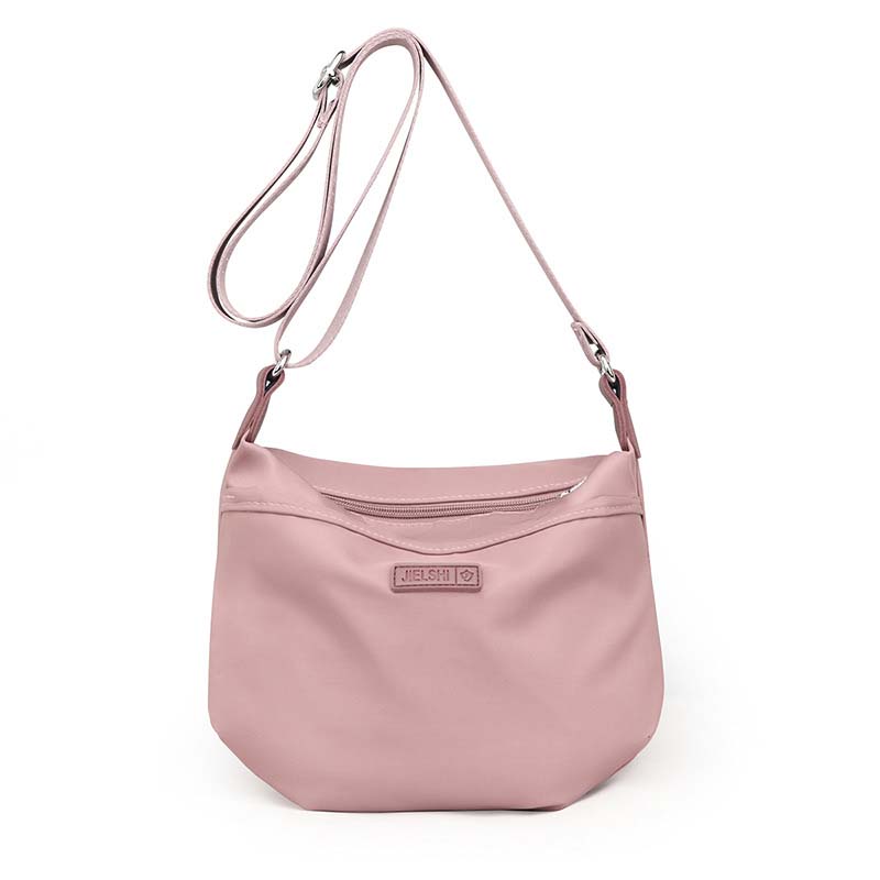 Dusty pink Joanna anti-theft waterproof crossbody shoulder bag with an adjustable strap and front zipper pocket.