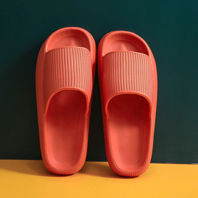 Fitlybuy orange cloud slippers with textured, ultra-soft memory foam, set against a two-tone green and yellow backdrop.