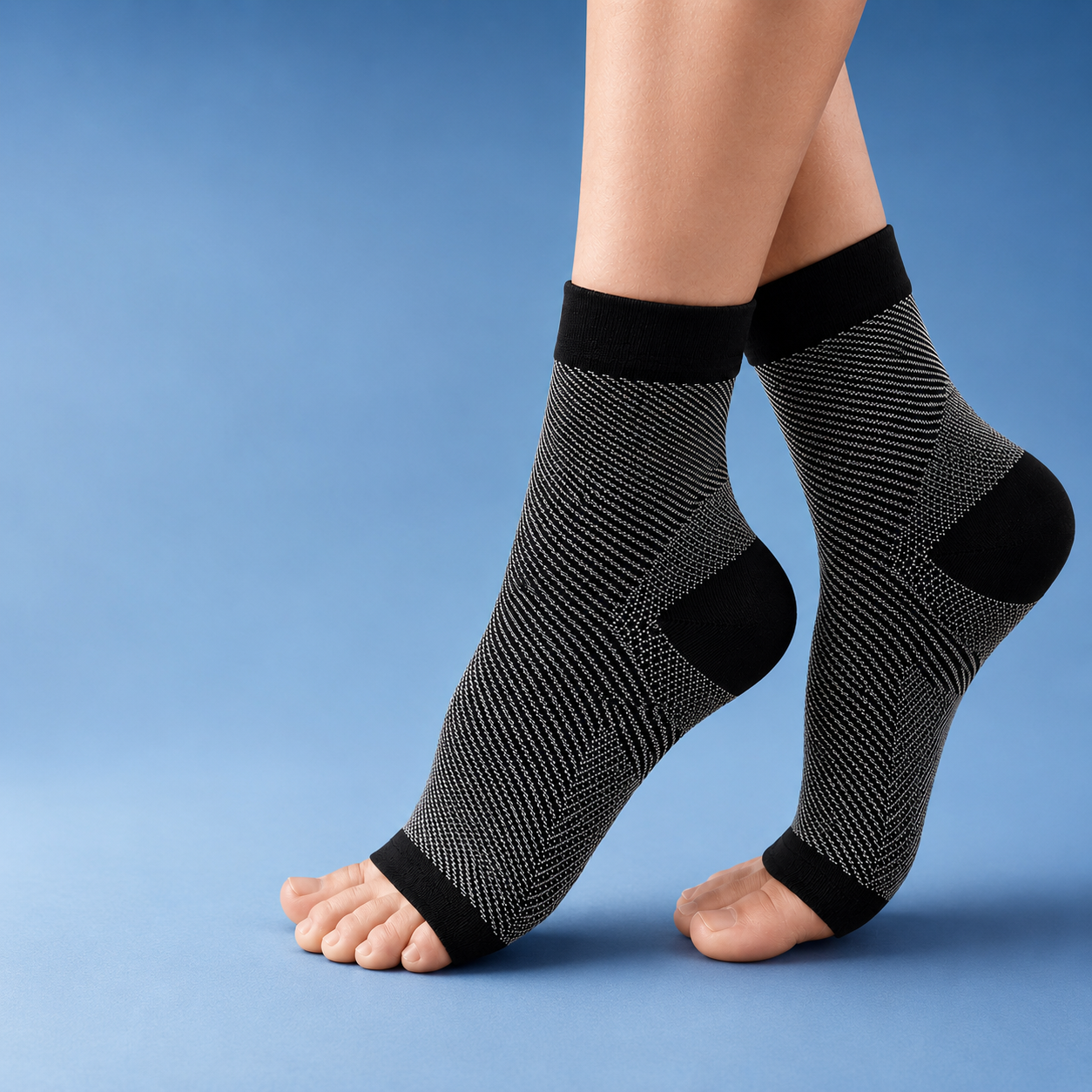Fitlybuy black and white compression ankle socks with open-toe design and support technology against a blue background.
