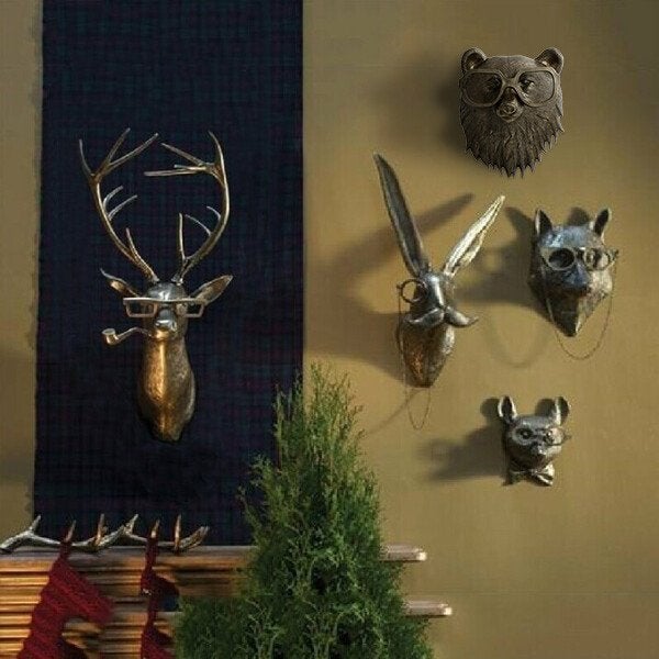 Bronze-colored animal head wall decor featuring a deer, rabbit, fox, bear, and cat wearing quirky glasses and accessories.
