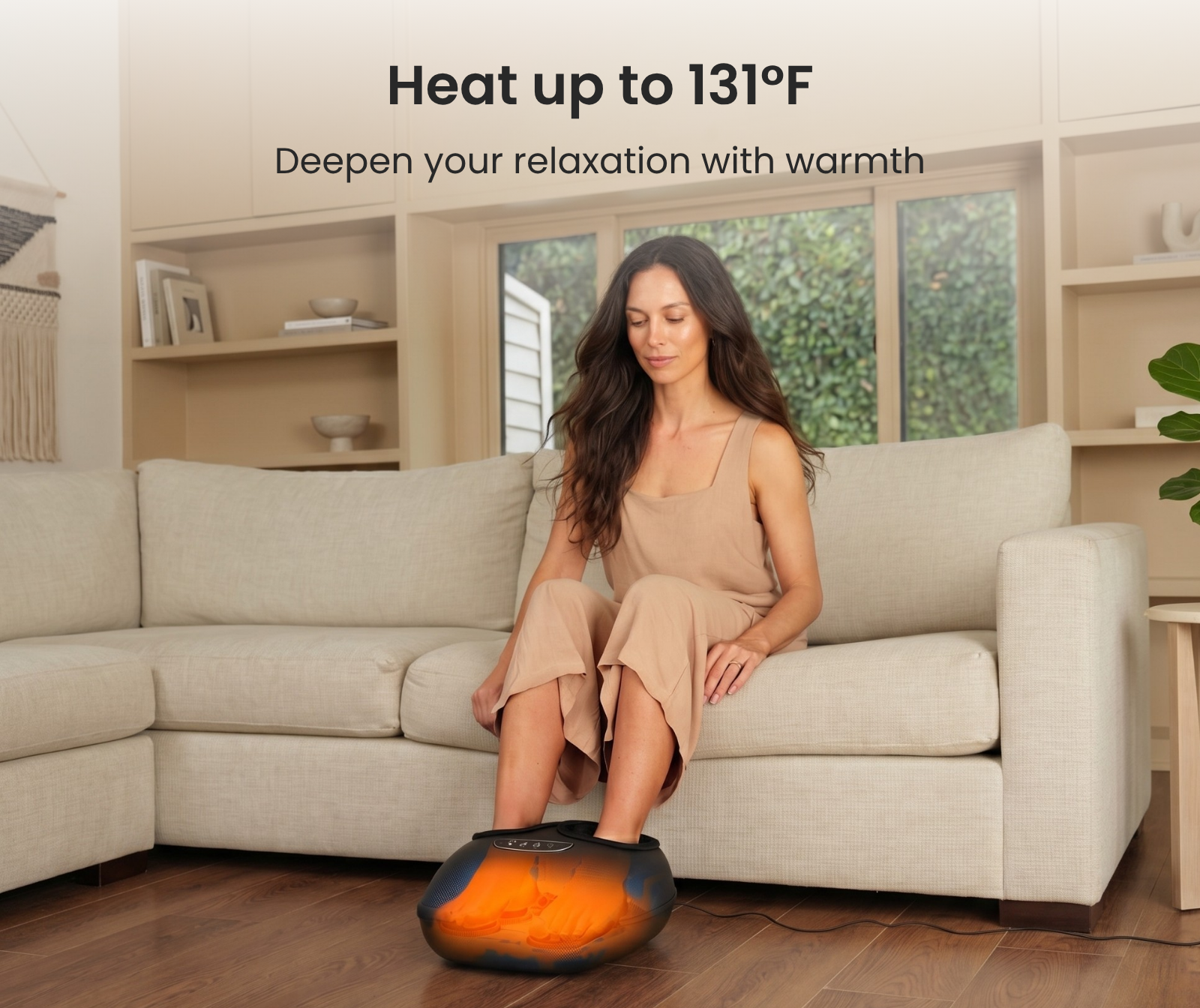 Woman on a couch using a black Fitlybuy Solheel foot massager, glowing orange to show heat up to 131°F.