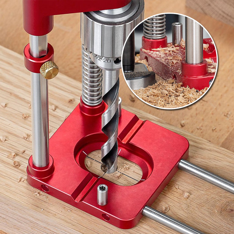 Fitlybuy red aluminum woodworking drill locator base with adjustable guide rails and drill bit on a wood board.