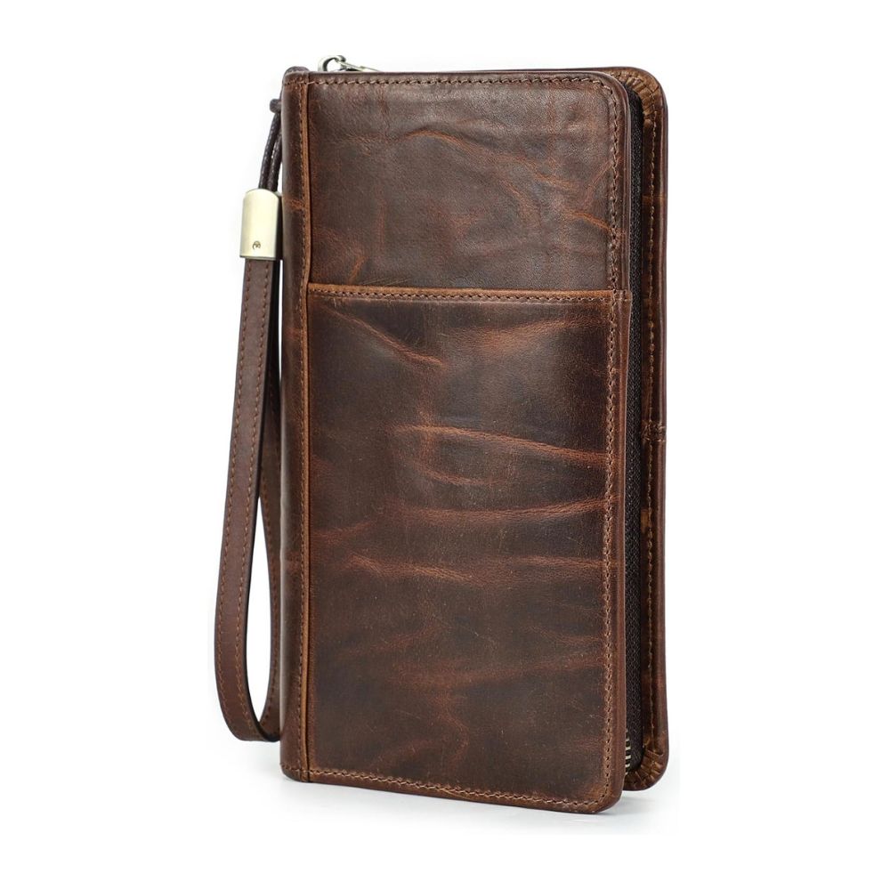 Brown top-grain leather travel wallet with wrist strap, zip closure, and RFID-secure technology against white.