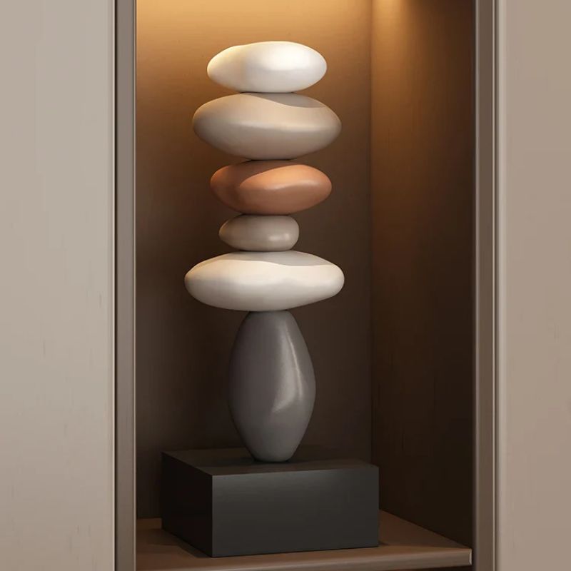 Fitlybuy Balanture Zen sculpture: a vertical stack of smooth, multi-colored stones on a black base in a lit alcove.