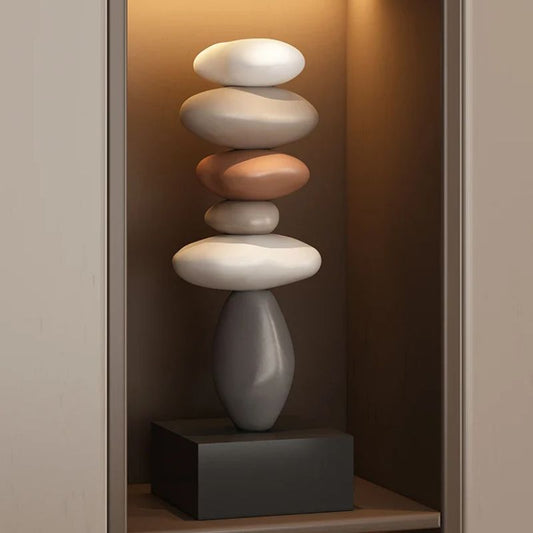 Fitlybuy Balanture Zen sculpture: a vertical stack of smooth, multi-colored stones on a black base in a lit alcove.