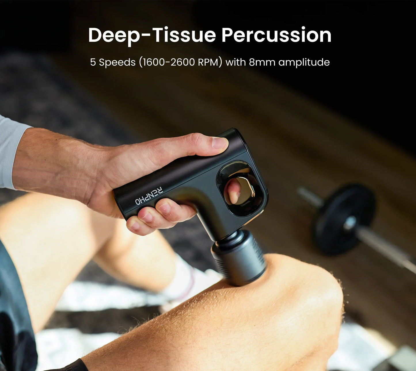 Compact black Fitlybuy Thermacool massage gun massaging a knee with heat therapy; gym setting background.