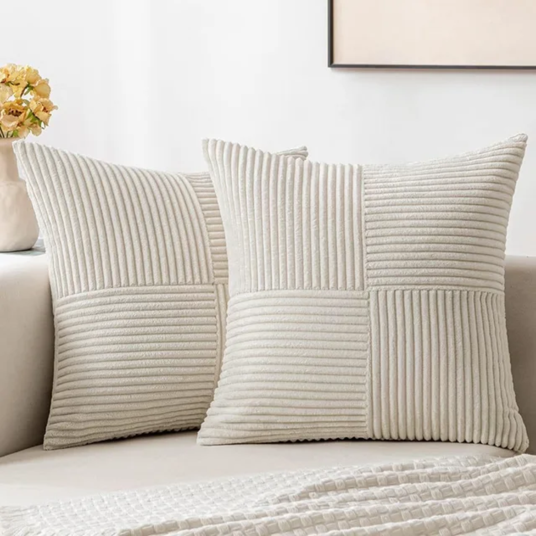 Two cream-colored, ribbed, square decorative cushions with a checkerboard texture on a sofa.