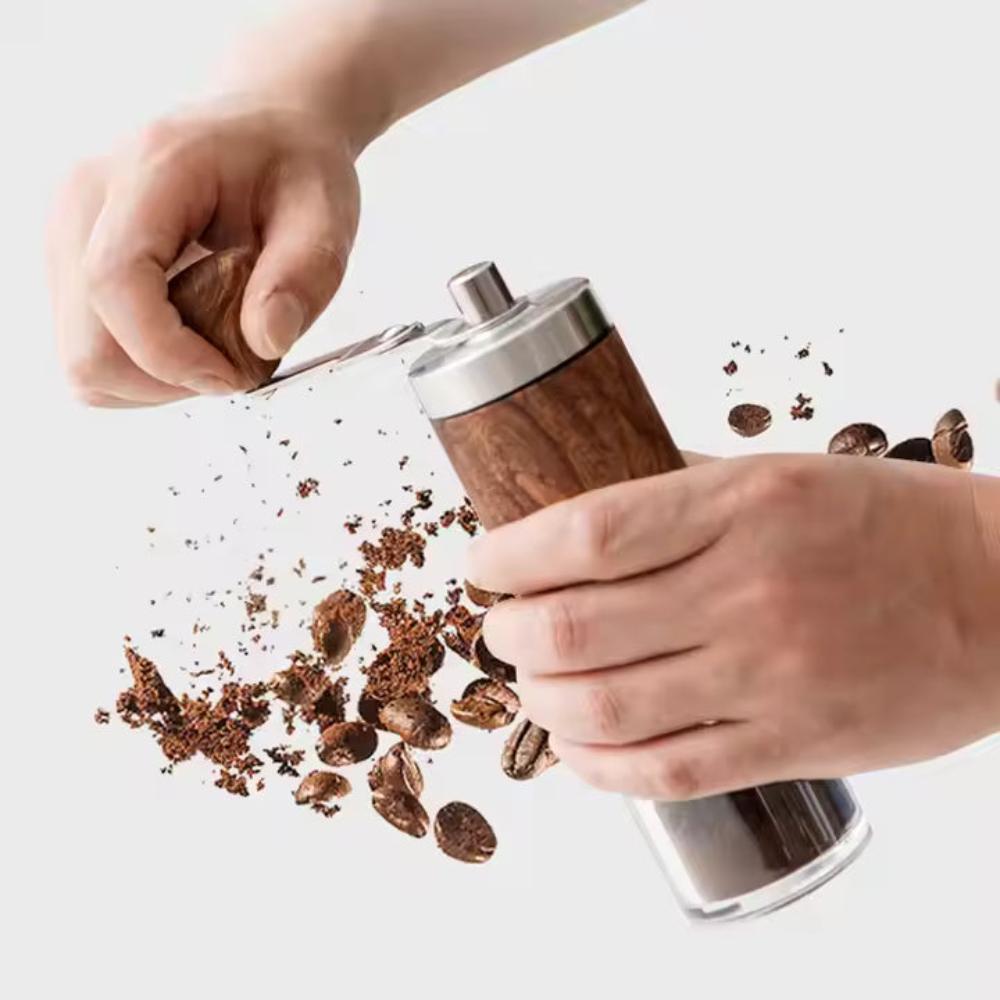 Handcrafted wooden coffee grinder with adjustable precision settings, shown in use with flying coffee beans and grounds.