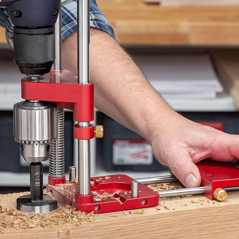 Fitlybuy red precision woodworking drill guide with adjustable depth stops used on a wood board in a workshop.