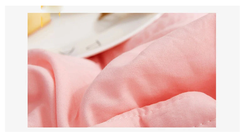 Close-up of a soft, pastel pink Fitlybuy premium cooling blanket with visible stitched texture.