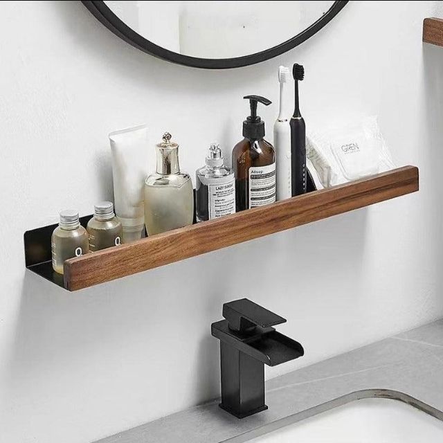 Fitlybuy no-drill solid wood bathroom shelf with black metal base, holding toiletries above a modern bathroom sink.