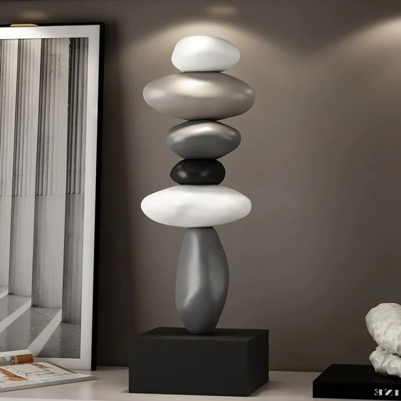 Fitlybuy Balanture zen sculpture featuring stacked gray, white, and black smooth stones on a black base in a modern room.