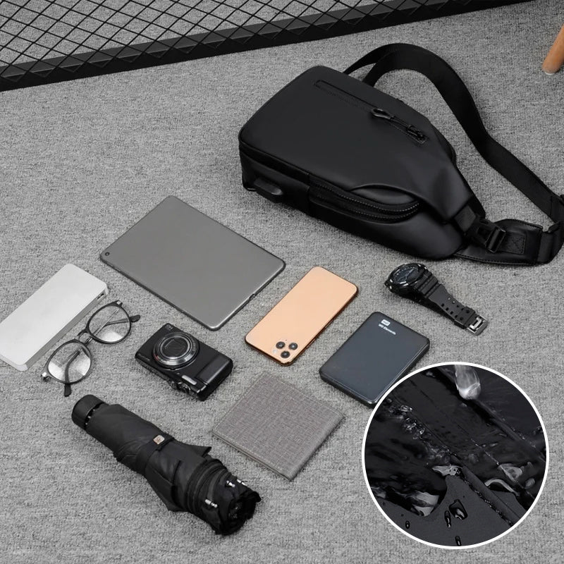 Fitlybuy black waterproof anti-theft crossbody bag with SecureLock tech, displayed with travel accessories on gray carpet.