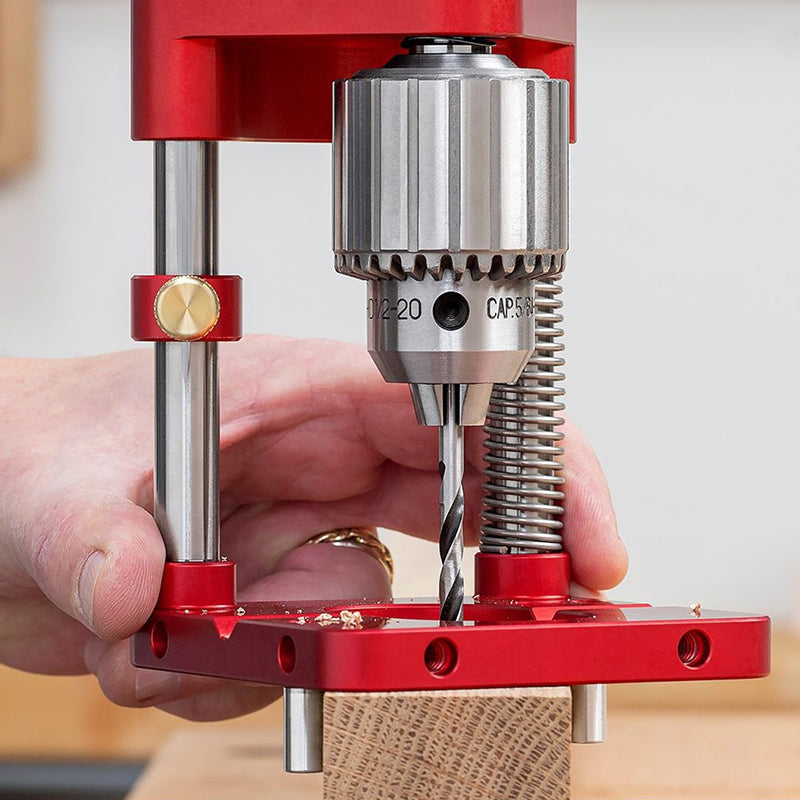 Red Fitlybuy woodworking locator with drill chuck, depth stop, and guide rails positioned over a wooden block.