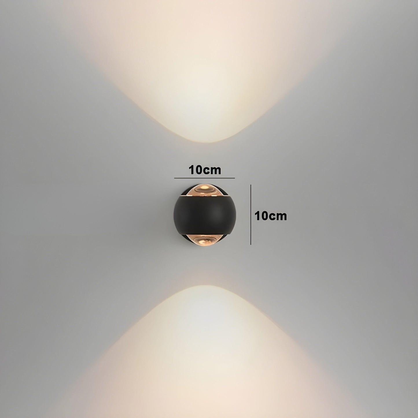 ModernEdge round black LED wall light emitting upward and downward beams. 10x10cm size marked on a neutral wall.