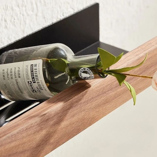 Fitlybuy solid wood and black metal wall-mounted bathroom shelf holding a glass bottle with greenery.